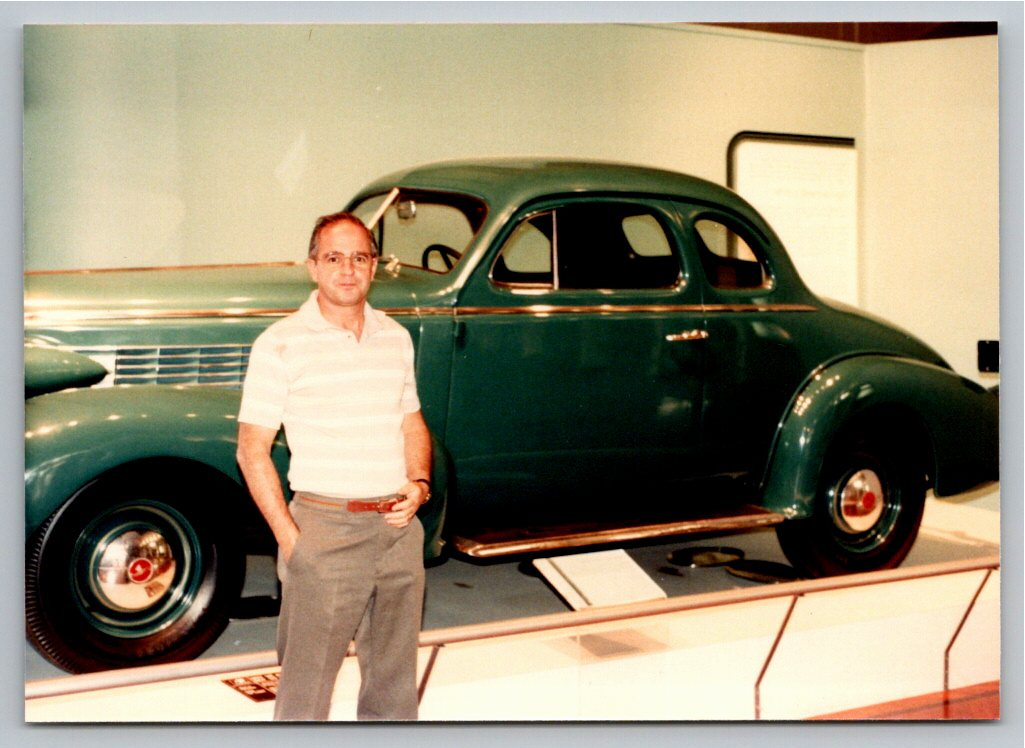 Vintage 1980s Color Photo: Man Posing with Green Classic Coupe